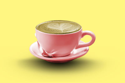 Close-up of coffee cup against yellow background