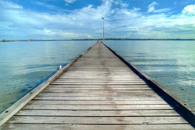 Pier over lake against sky