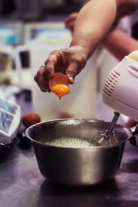 Cropped hand of woman mixing egg in bowl