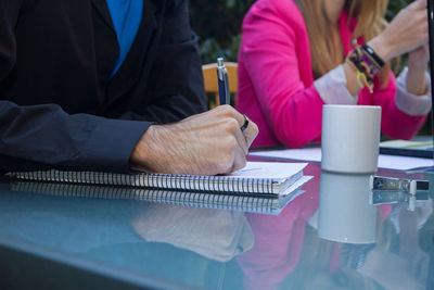 Midsection of people sitting at table