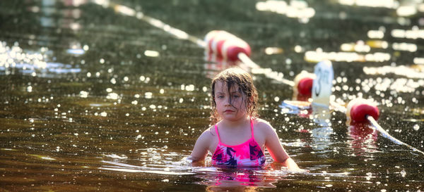 Rear view of young woman swimming in lake