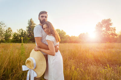 Young couple kissing against plants against sky