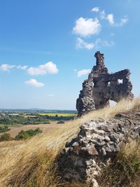 Old ruins on field against sky