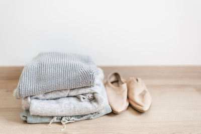 High angle view of stacked sweaters and shoes on floor