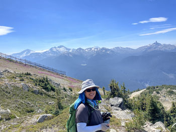 Rear view of man standing on mountain against sky