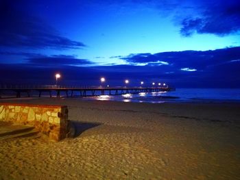 Scenic view of beach against blue sky at night