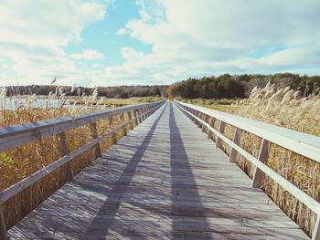 Footbridge over road against sky