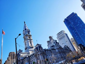 Low angle view of modern buildings against blue sky