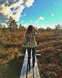 Rear view of woman walking on boardwalk