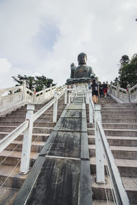 Low angle view of staircase against cloudy sky