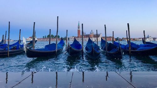 Boats moored in sea against clear sky