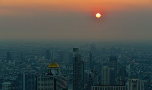 Aerial view of buildings in city during sunset