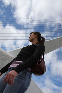 Low angle view of woman standing against sky