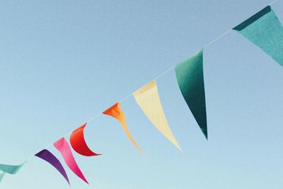 Low angle view of flags hanging against the sky