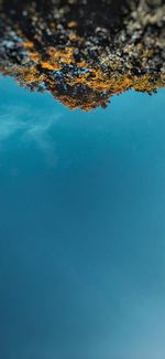 High angle view of rocks in sea against blue sky