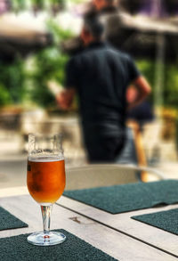 Reflection of man in glass on table