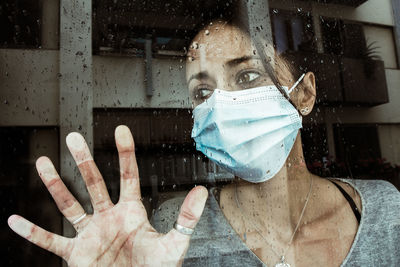 Portrait of man looking through glass window