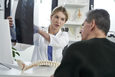 Side view of doctor examining patient in office