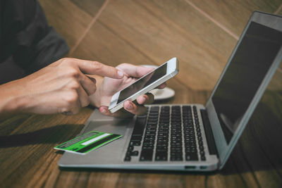 Midsection of man using mobile phone on table