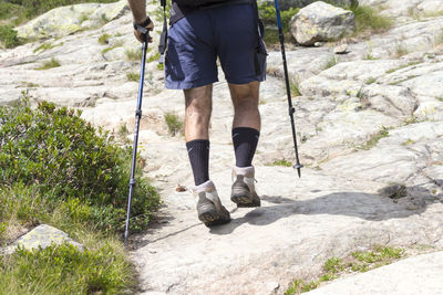 Low section of man hiking on rock
