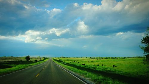 Country road against cloudy sky