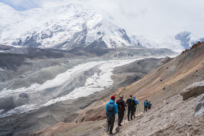 Rear view of people walking on mountain