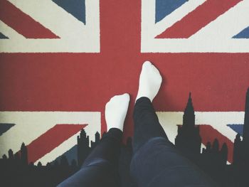 Low section of man standing on british flag