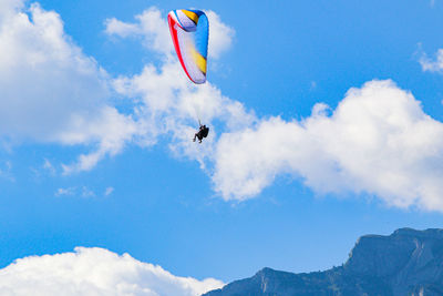 Low angle view of person paragliding against sky