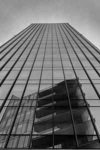 Low angle view of modern glass building against sky
