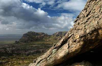 Scenic view of rocky mountains against dramatic cloudy sky