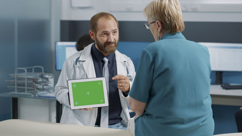 Doctor showing digital tablet to patient