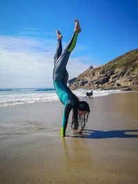 Full length of woman exercising at beach