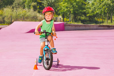 Portrait of boy riding bicycle on road