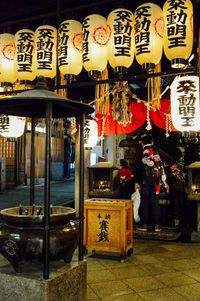 Illuminated lanterns hanging in store at night