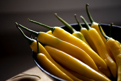 Yellow natural chilli pepper on a black kitchen plate