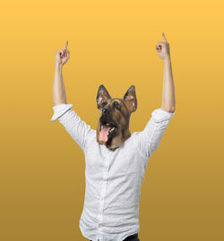 Portrait of two people standing against yellow background