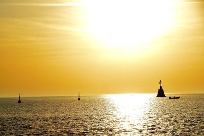 Silhouette sailboat in sea against sky during sunset