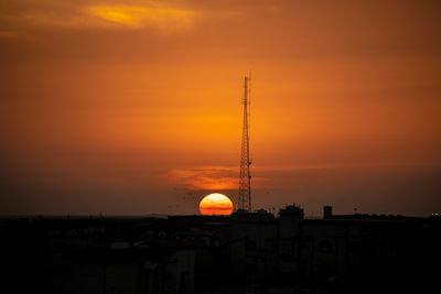 Silhouette tower against orange sky during sunset