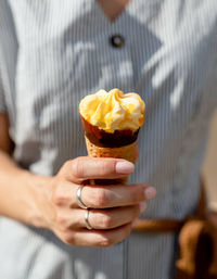 Woman hand holding ice cream cone outdoors