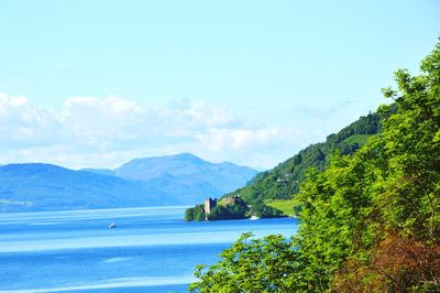Scenic view of sea and mountains against sky