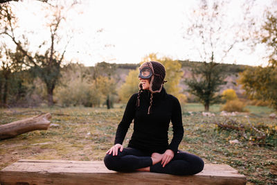 Full length of woman sitting on bench at park