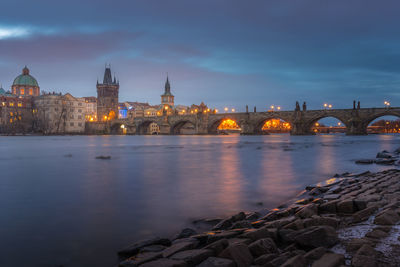 Arch bridge over river against buildings in city