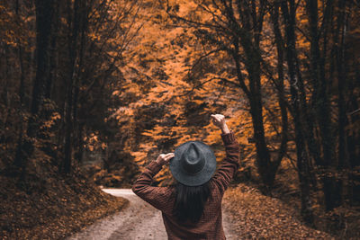 Portrait of person standing by trees in forest during autumn