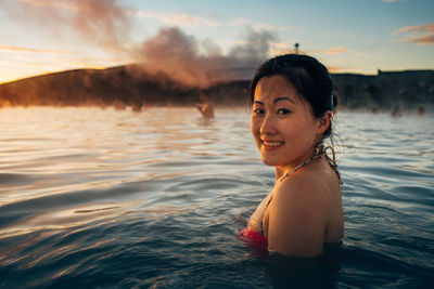 Portrait of young woman swimming in sea