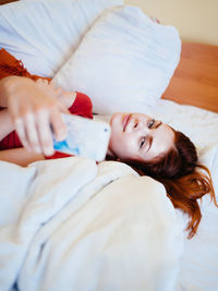 High angle view of woman lying on bed at home