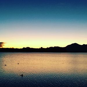 Scenic view of lake against clear sky during sunset