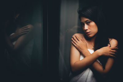 Portrait of woman wrapped in towel while standing at home