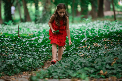 Woman standing by tree in forest