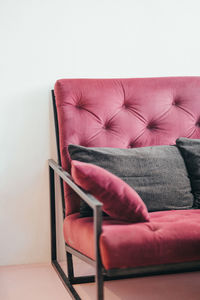 Empty chair against pink wall at home