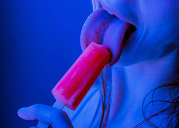 Midsection of woman licking popsicle
